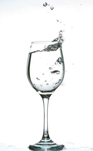 A captivating image of water splashing inside a wine glass against a white background.